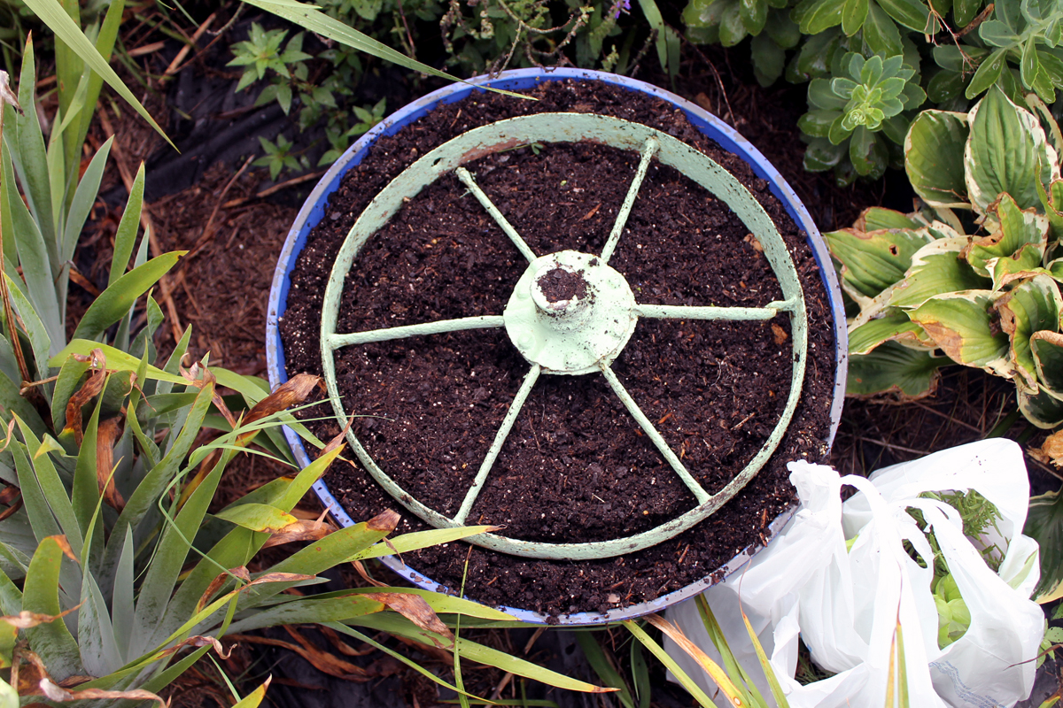 Painted wheel inside planter with soil